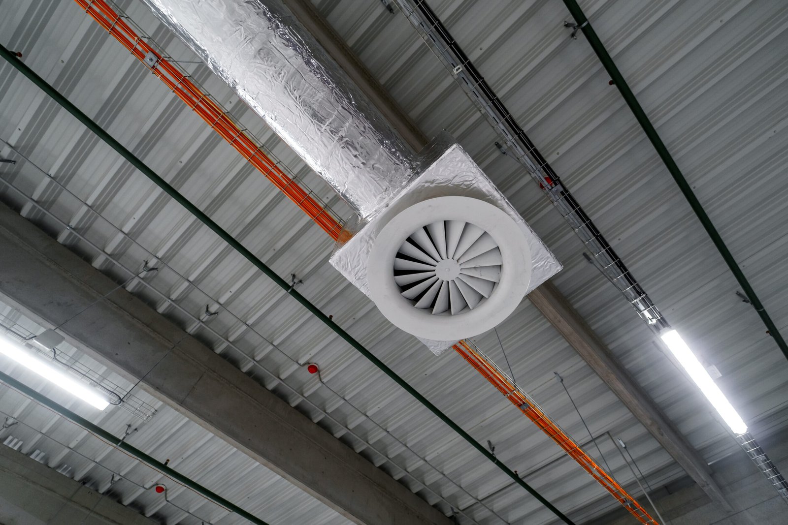 Large warehouse air distribution ductwork illustrating why fan external static pressure must match the duct network